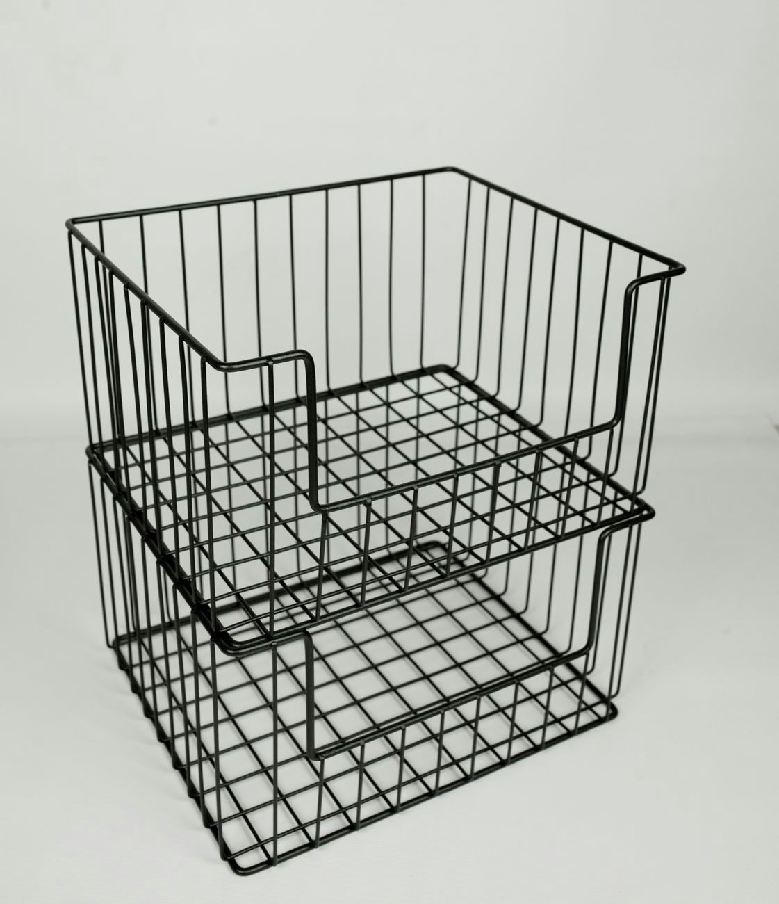 A minimalist black metal wire basket with clean lines on a white background, ideal for organization.