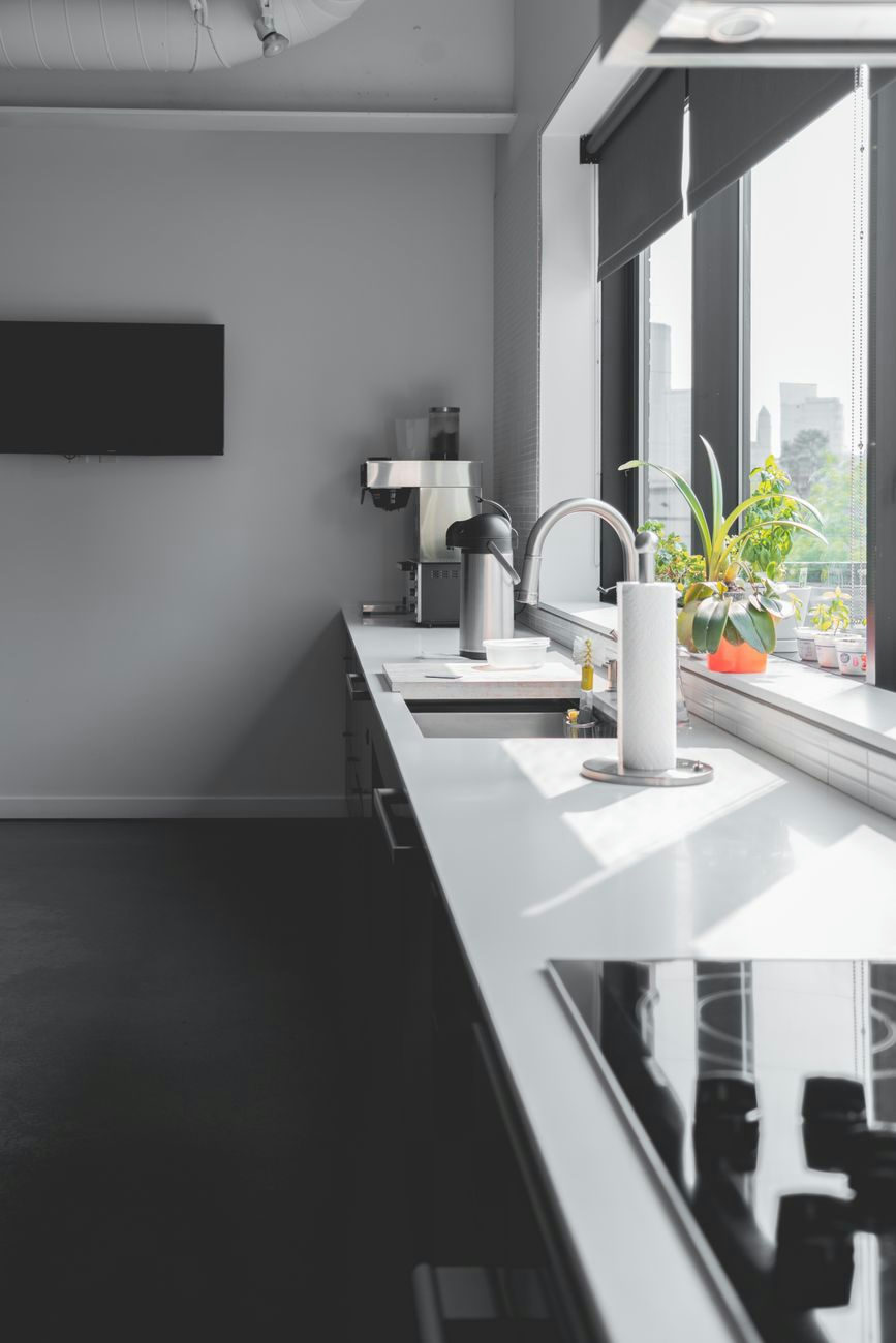 Sleek modern kitchen design featuring a sunlit countertop and large windows for a bright interior.