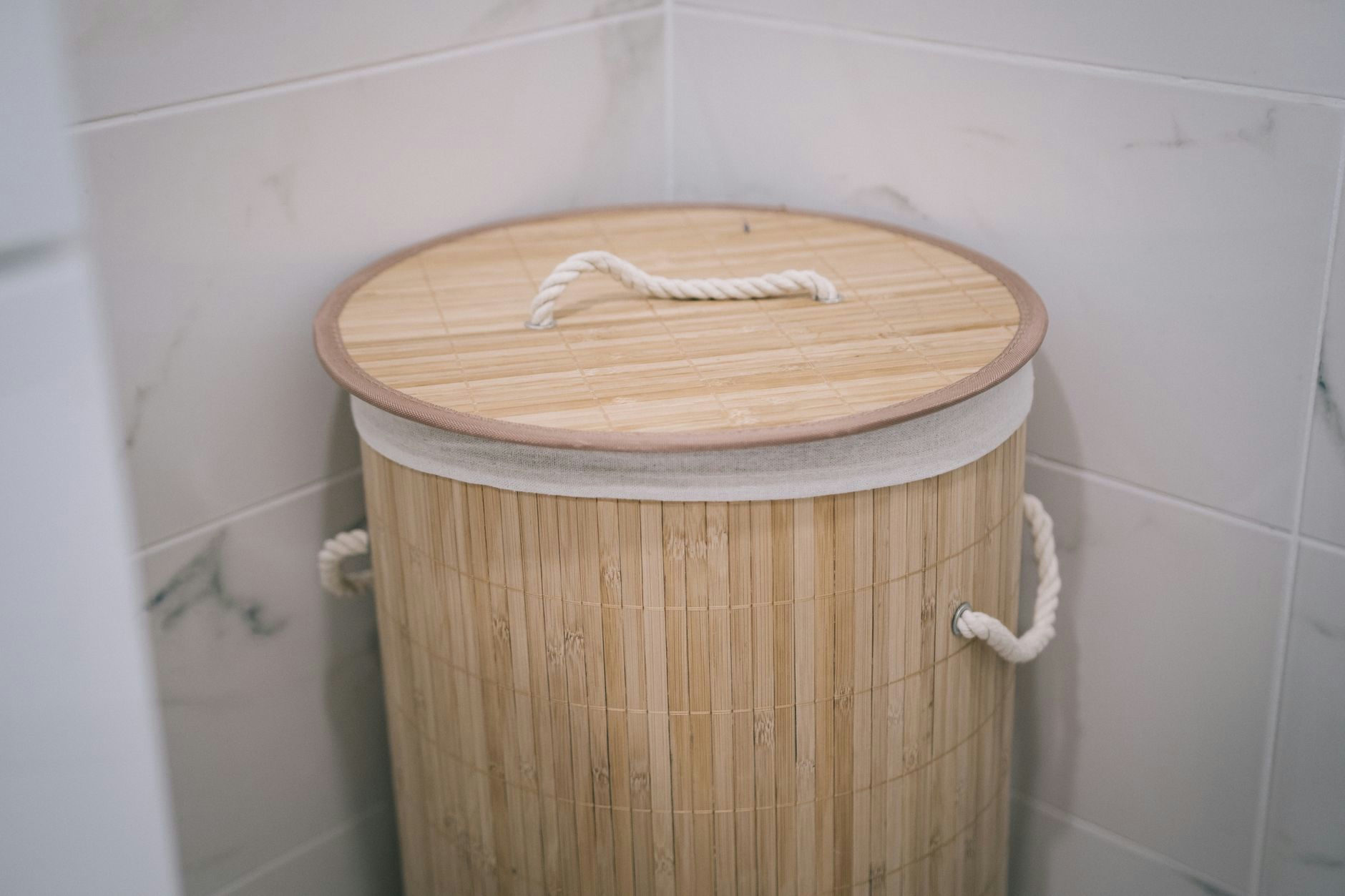 A stylish bamboo laundry basket adds a natural touch to a modern bathroom design.