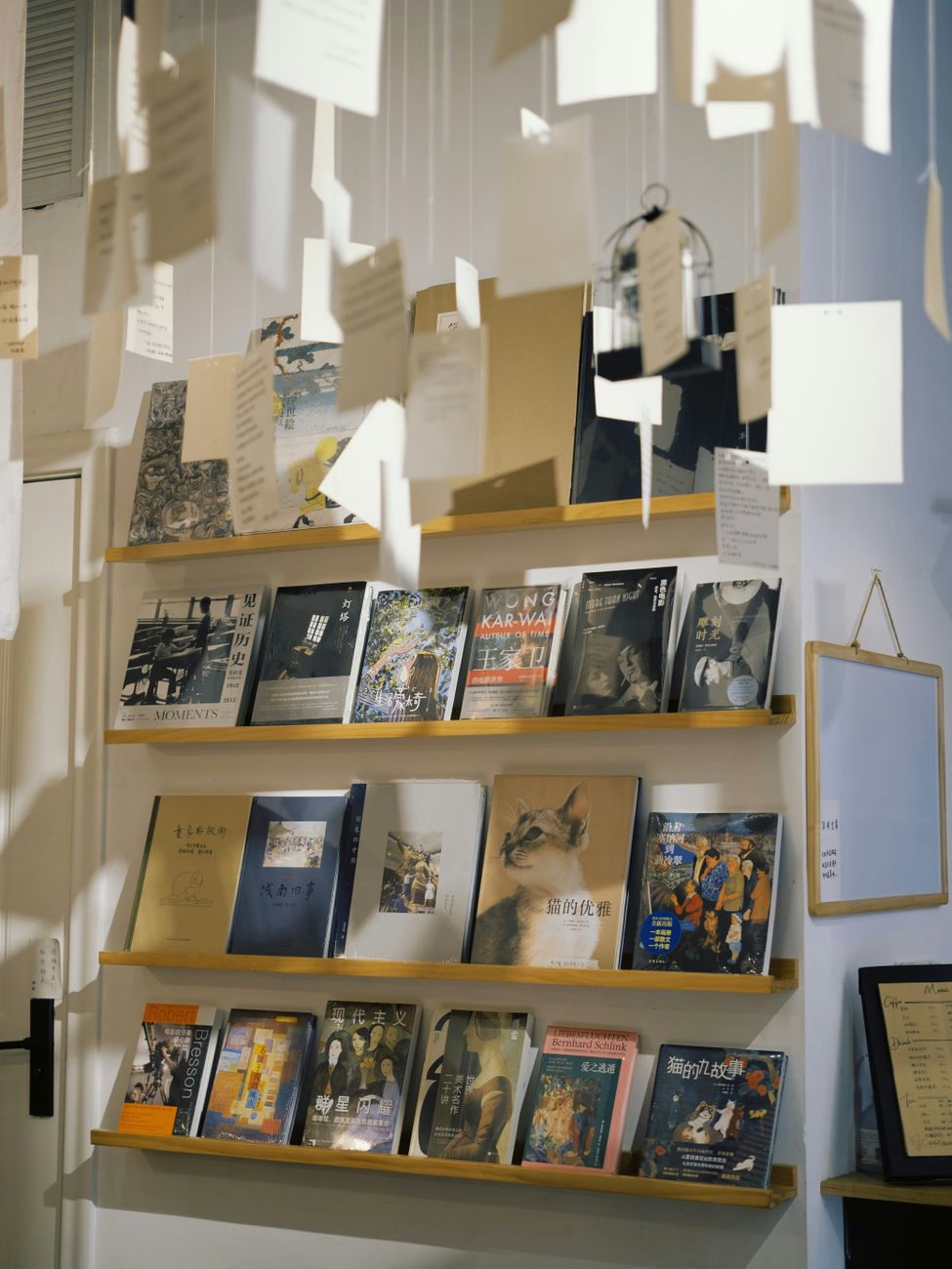 A cozy bookstore scene with books on wooden shelves and floating paper decorations.