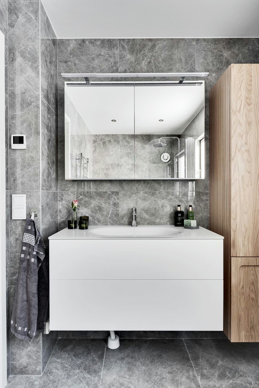 Contemporary bathroom with minimalist design featuring marble walls and sleek furniture.