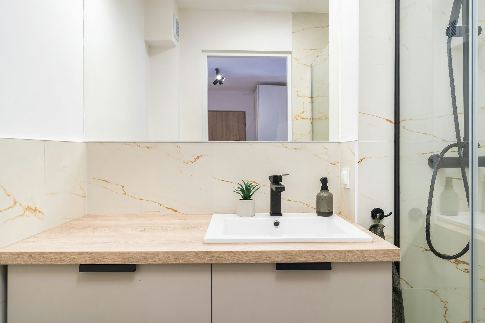 A minimalist bathroom vanity with wood countertop and elegant fixtures.