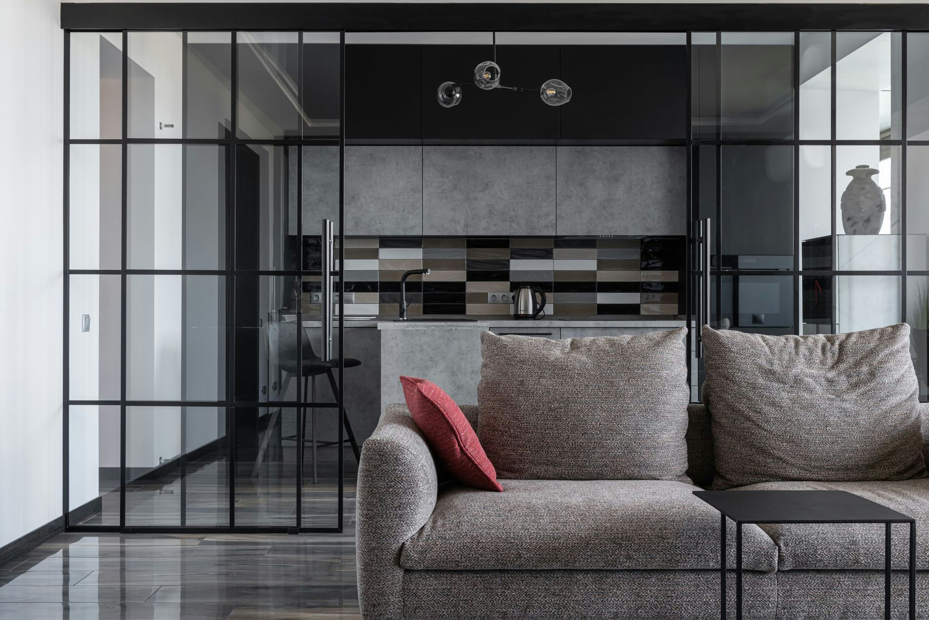 Contemporary living room with cozy sofa and open kitchen view.