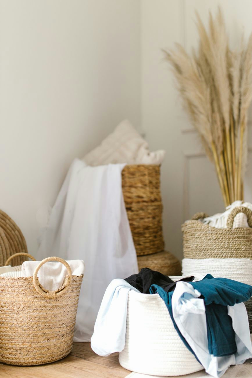 Stylish and cozy laundry room featuring woven baskets and dried pampas grass for decor.