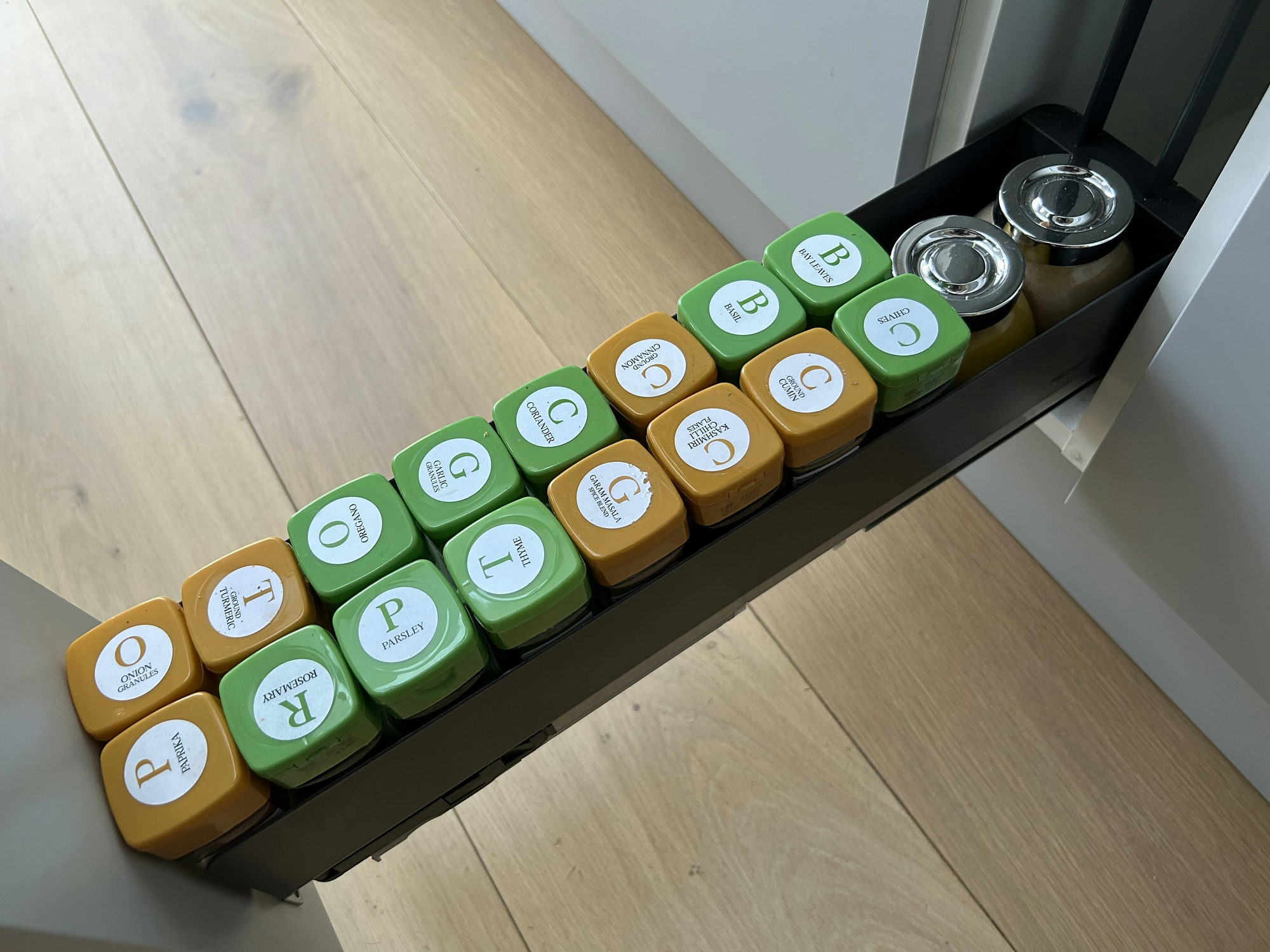 Pull out kitchen drawer showing spices arranged neatly.
